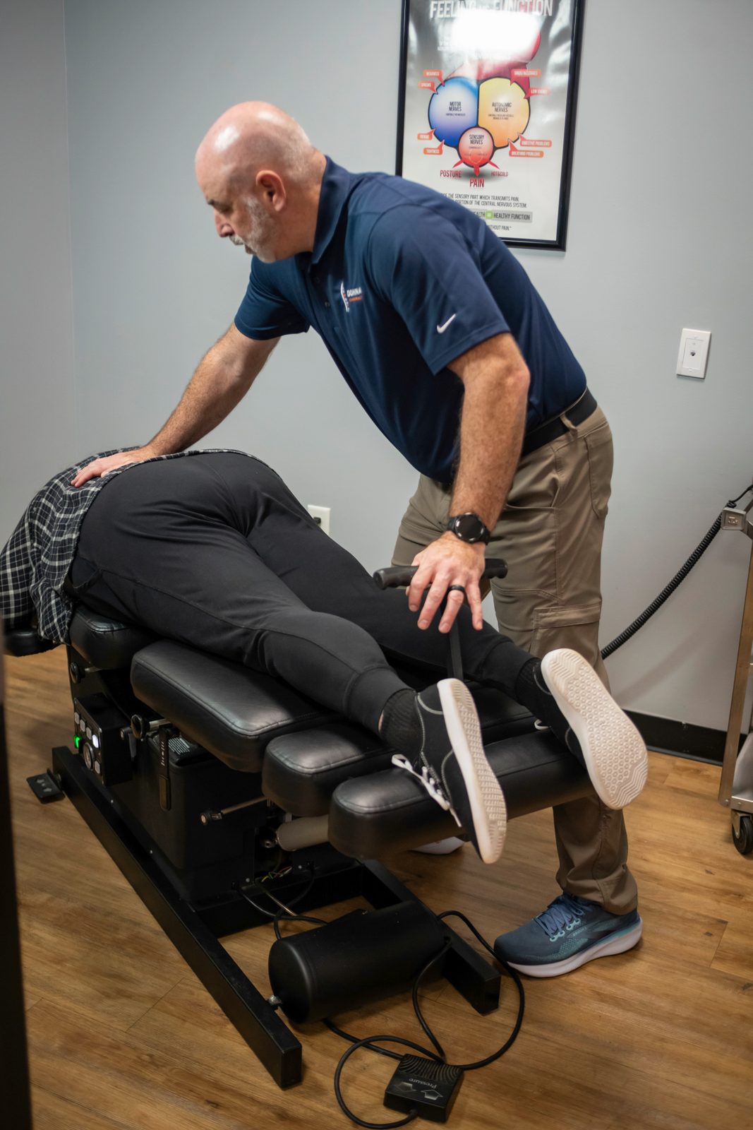 What Causes a Herniated Disc and How to Find Relief 2 Chiropractor performing hands-on lower back examination on patient seated on treatment table in clinical setting