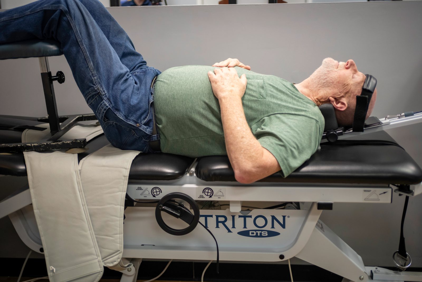 What Causes a Herniated Disc and How to Find Relief 1 Patient lying on motorized spinal decompression traction table with legs elevated during treatment